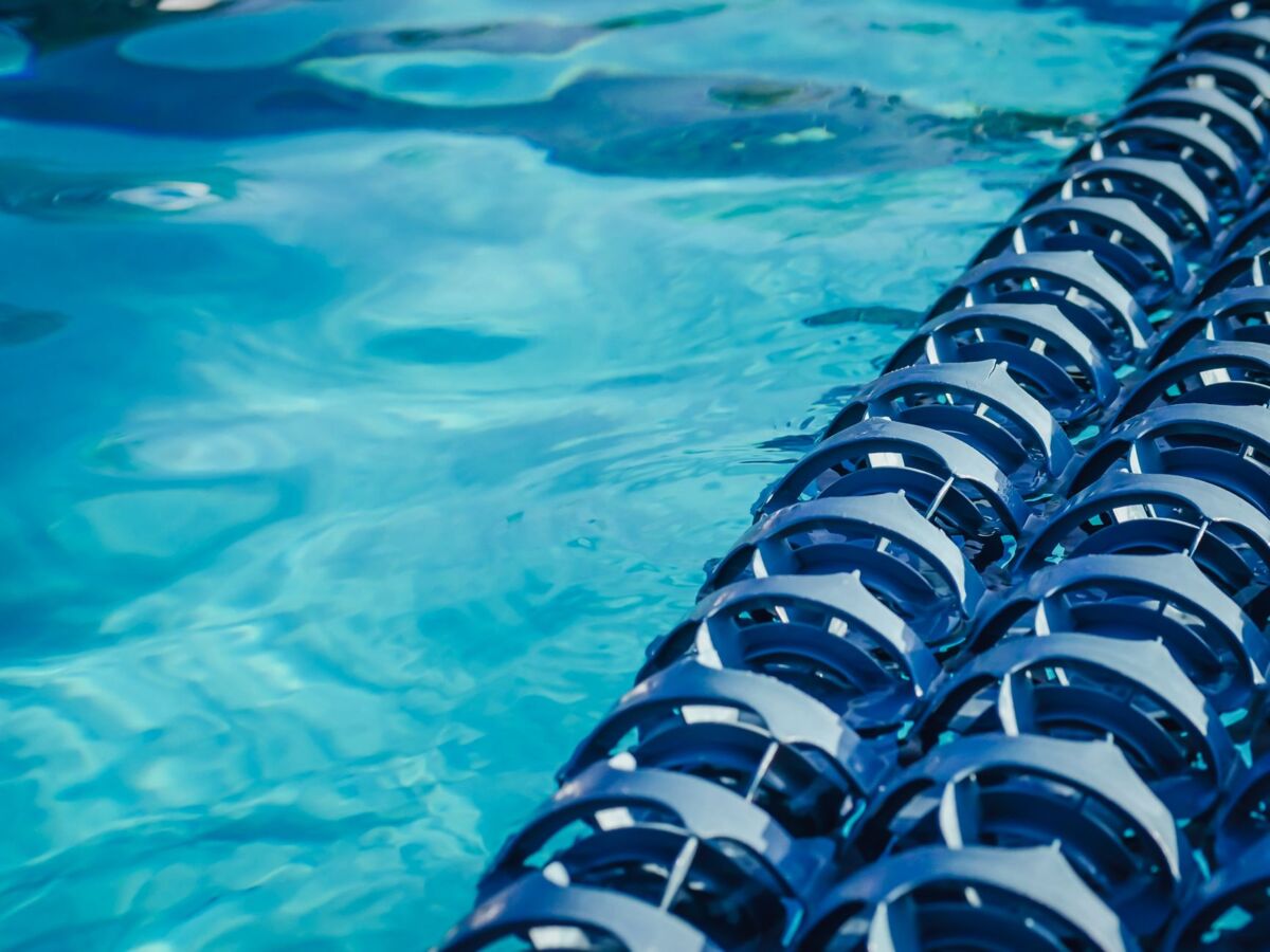 Blue swimming pool water with floating lane dividers, close-up view.