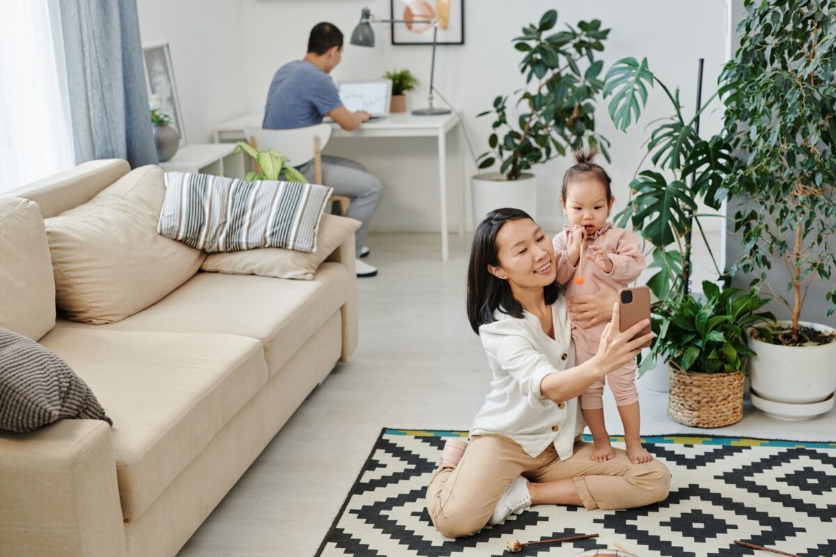 A mother and child enjoying a happy moment taking a selfie together in a cozy living room.