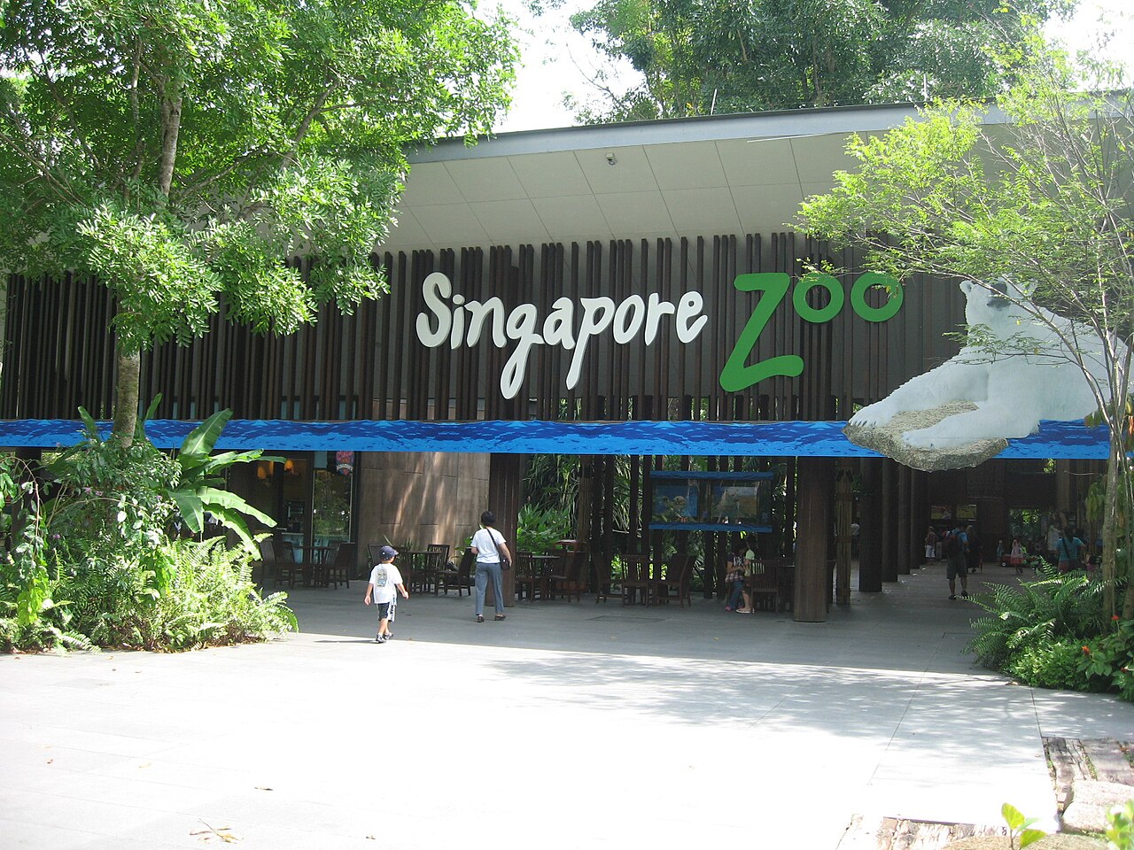 Singapore Zoo main entrance with the green Singapore Zoo sign and visitors walking in