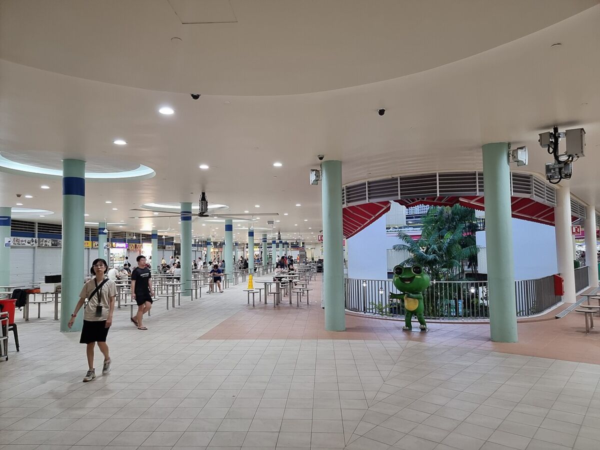Interior of Tiong Bahru Market food centre with diners and the area mascot