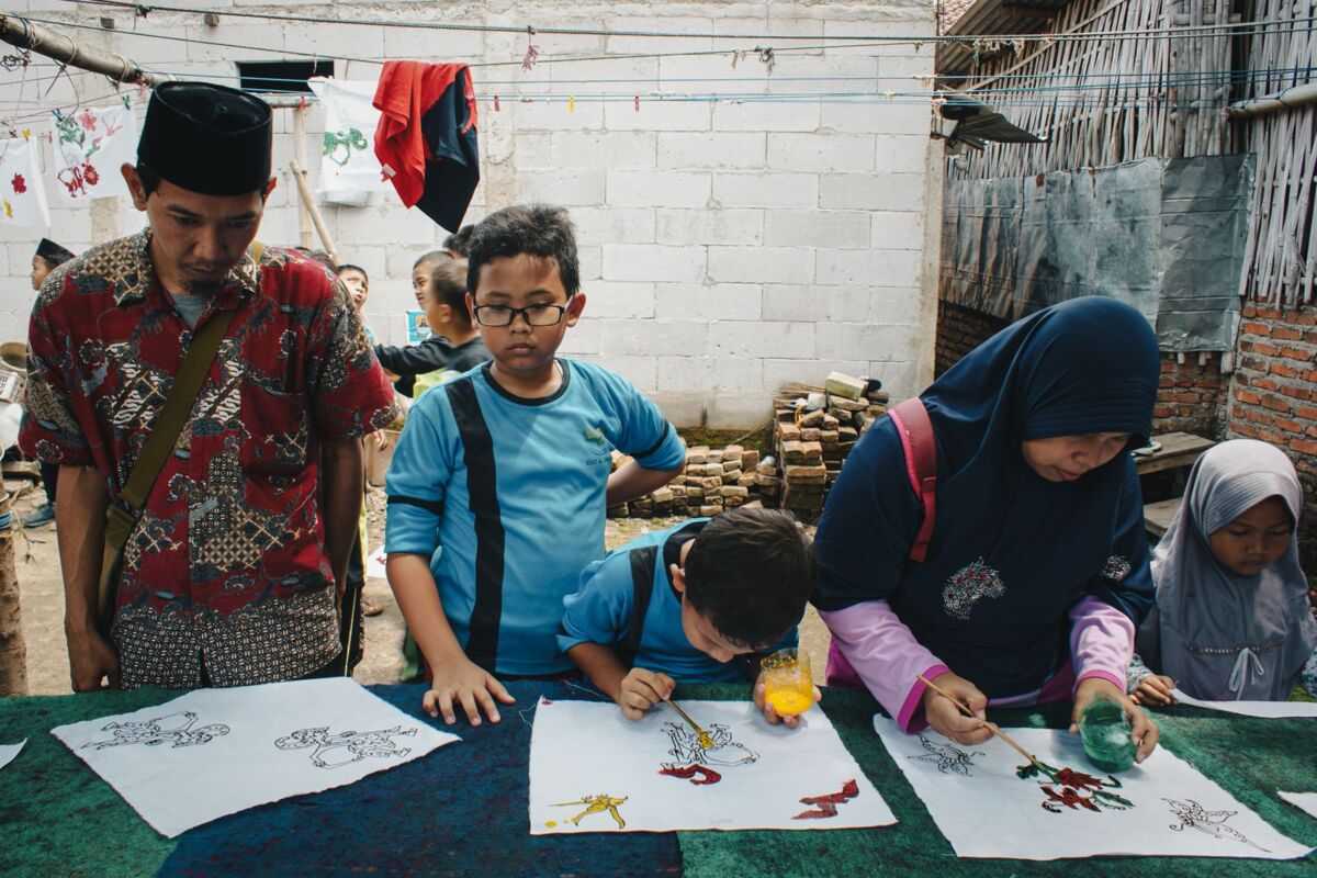 Children in West Java, Indonesia learn batik art, a traditional dyeing technique, in an outdoor craft class.